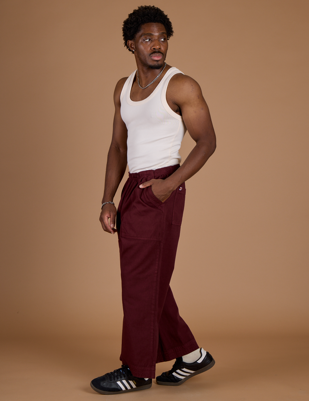 Side view of Isaac in the Red Wine Action Pant