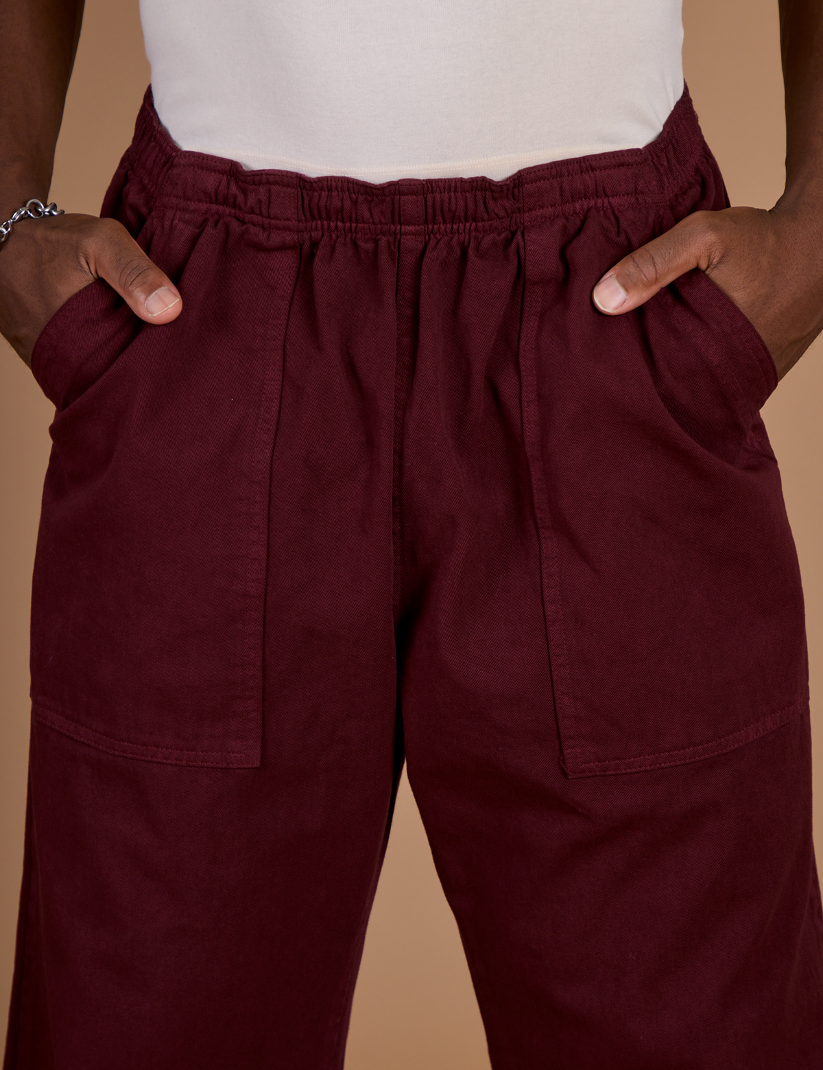 Close up of Isaac's hands in the front pockets of the Red Wine Action Pant