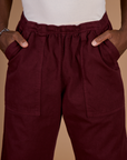 Close up of Isaac's hands in the front pockets of the Red Wine Action Pant