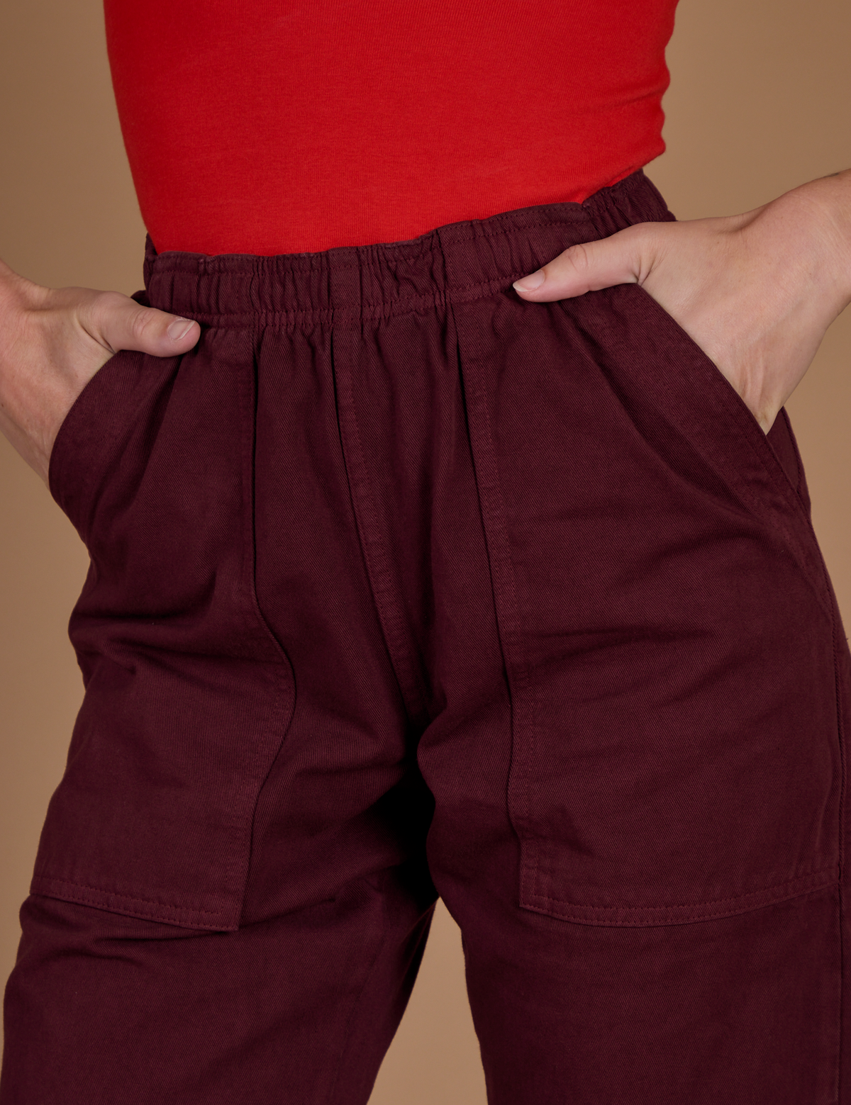 Close up of Alex's hands in the front pockets of the Red Wine Action Pant