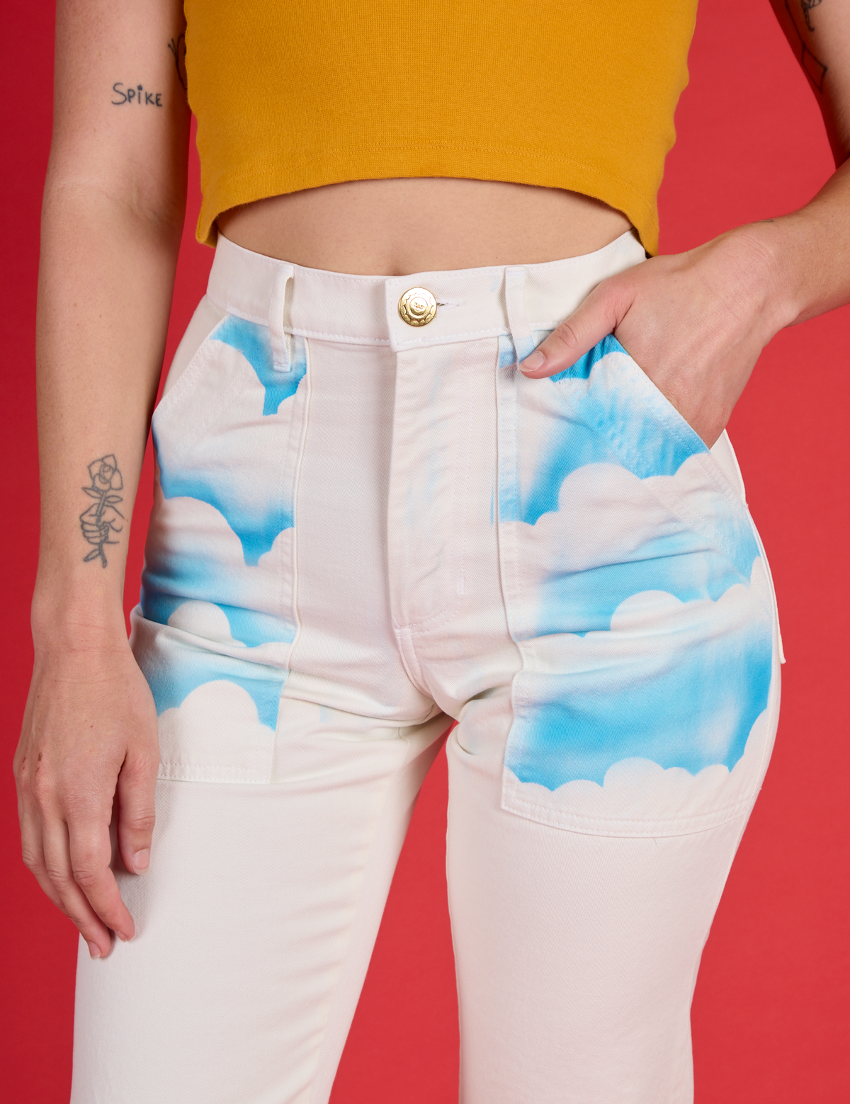 Alex's hand in the front pocket of the Pockets of Sky Airbrush Work Pants