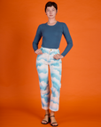 Alex is wearing the Cloud Coverage Airbrush Work Pants with Long Sleeve French Blue Baby Tee