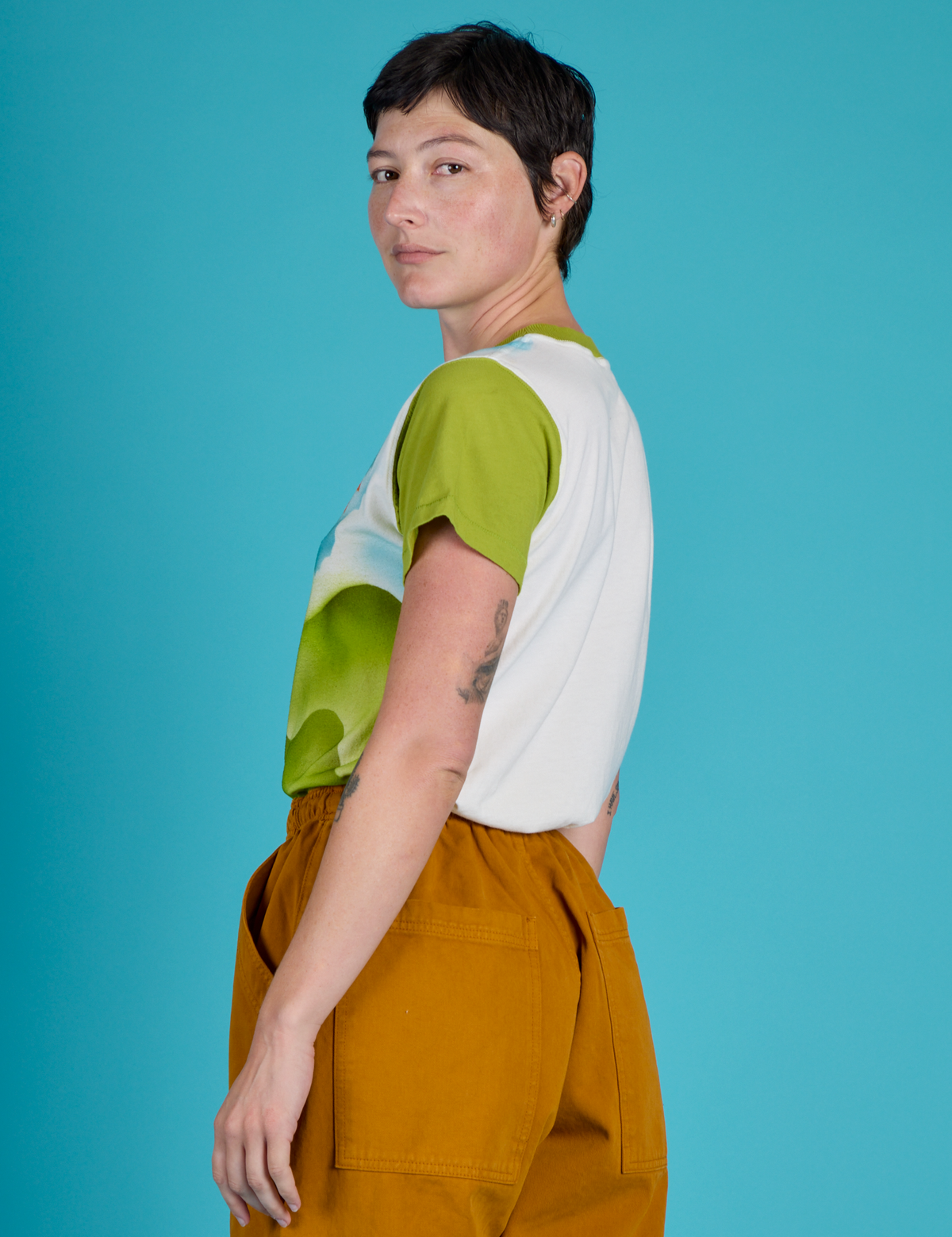 Angled back view of Alex in the Green Hills Airbrush Vintage Tee
