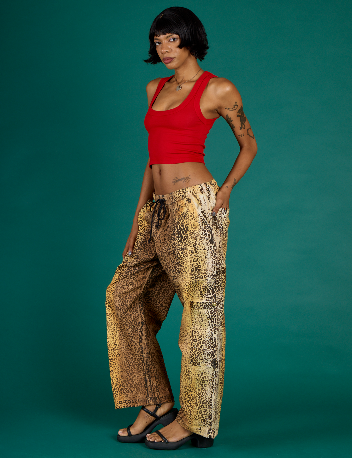 Angled side view of Kira wearing the Leopard Drop Pocket Pant