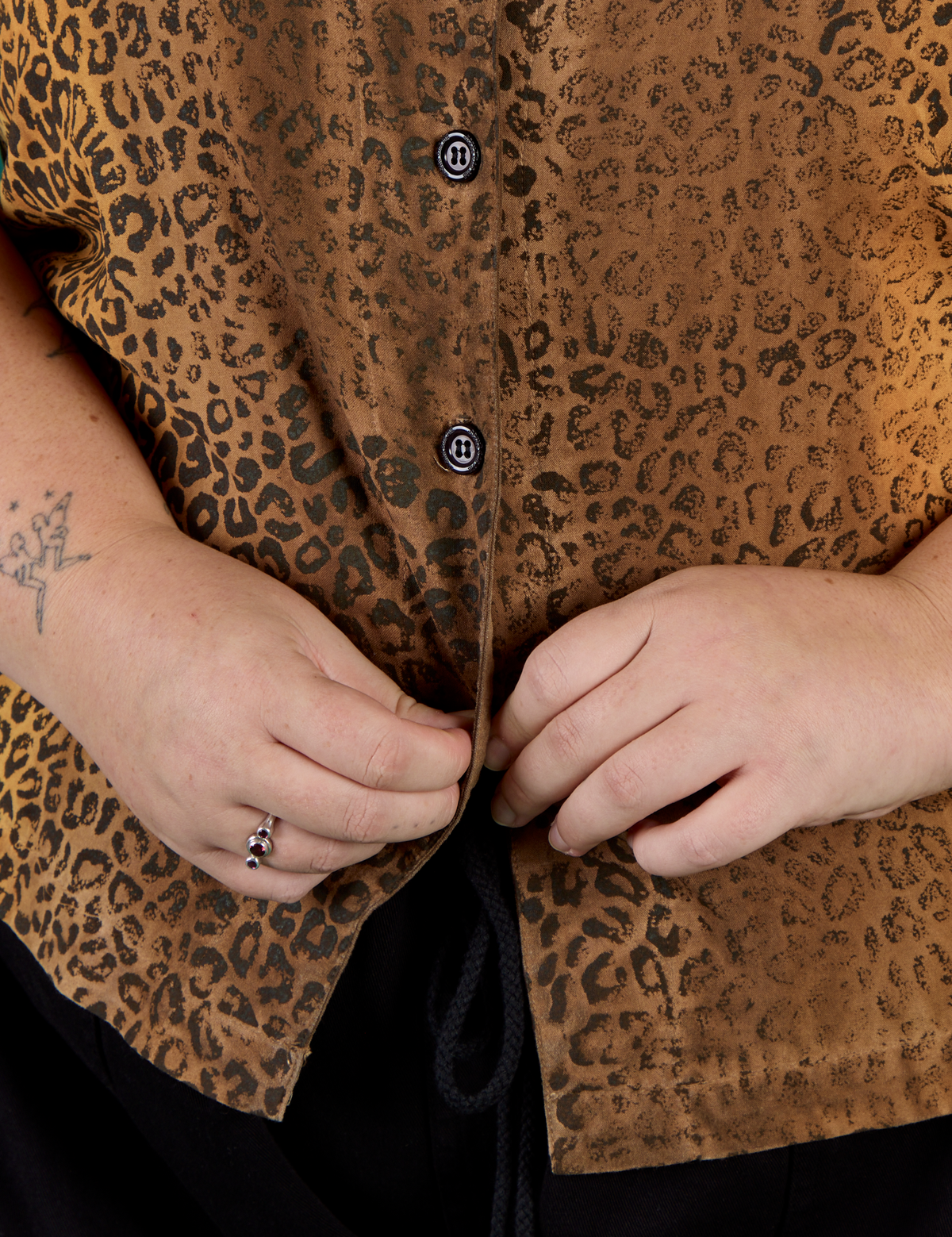 Close up on Juliet buttoning up the Leopard Pantry Button Up