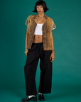 Kira is 5'10" and wearing XXS Leopard Pantry Button Up with the Black Drop Pocket Pants