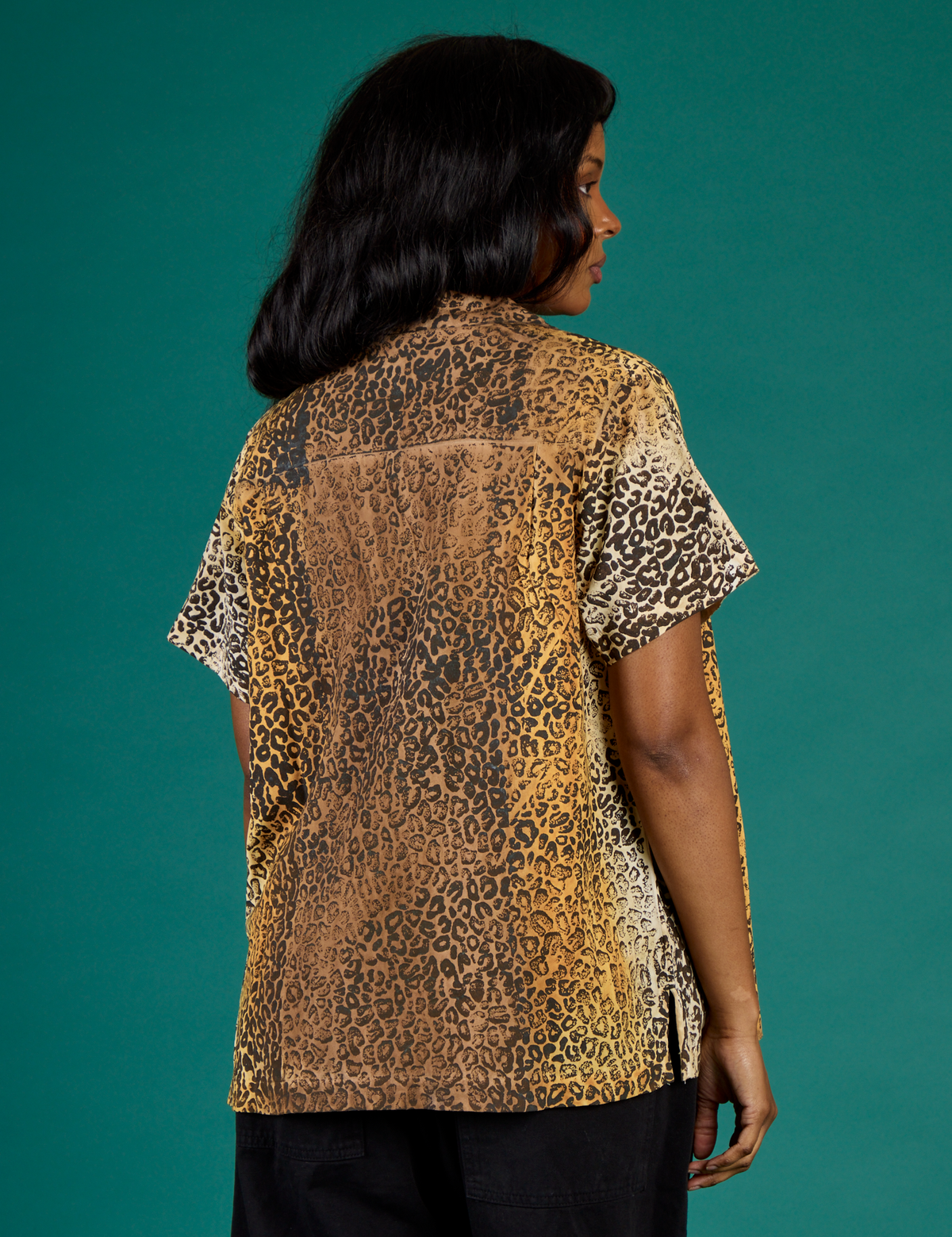 Angled back view of Kandia wearing the Leopard Pantry Button Up
