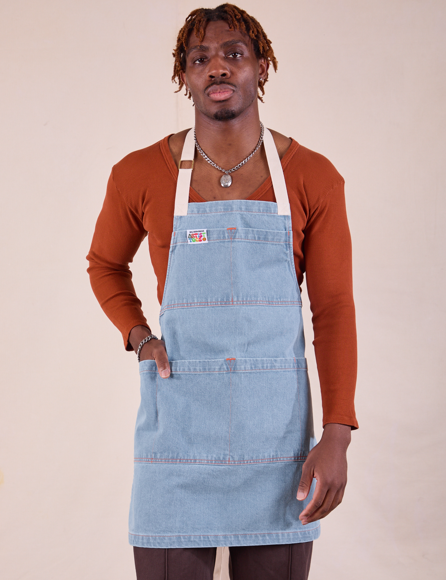 Isaac is wearing the light wash Full Indigo Denim Apron