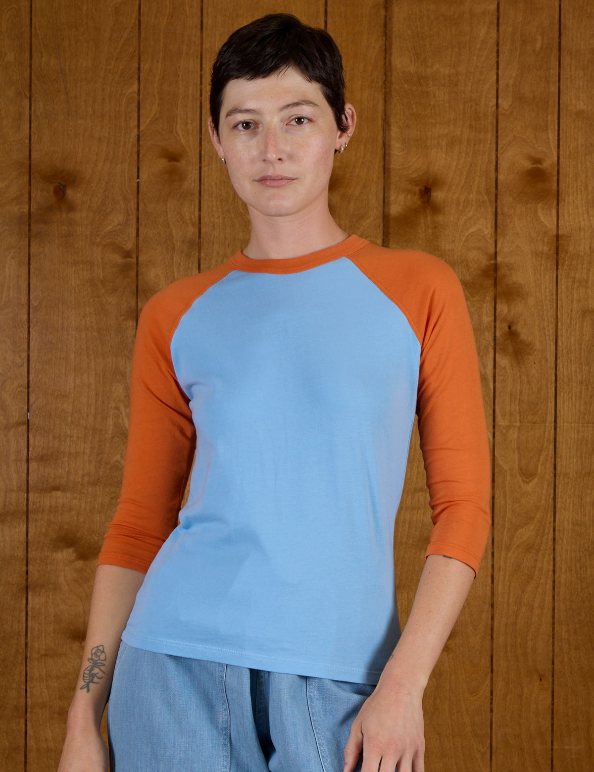 Alex is 5'8" and wearing P Baby Blue/Orange Colorblock Raglan Tee