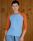 Alex is 5'8" and wearing P Baby Blue/Orange Colorblock Raglan Tee