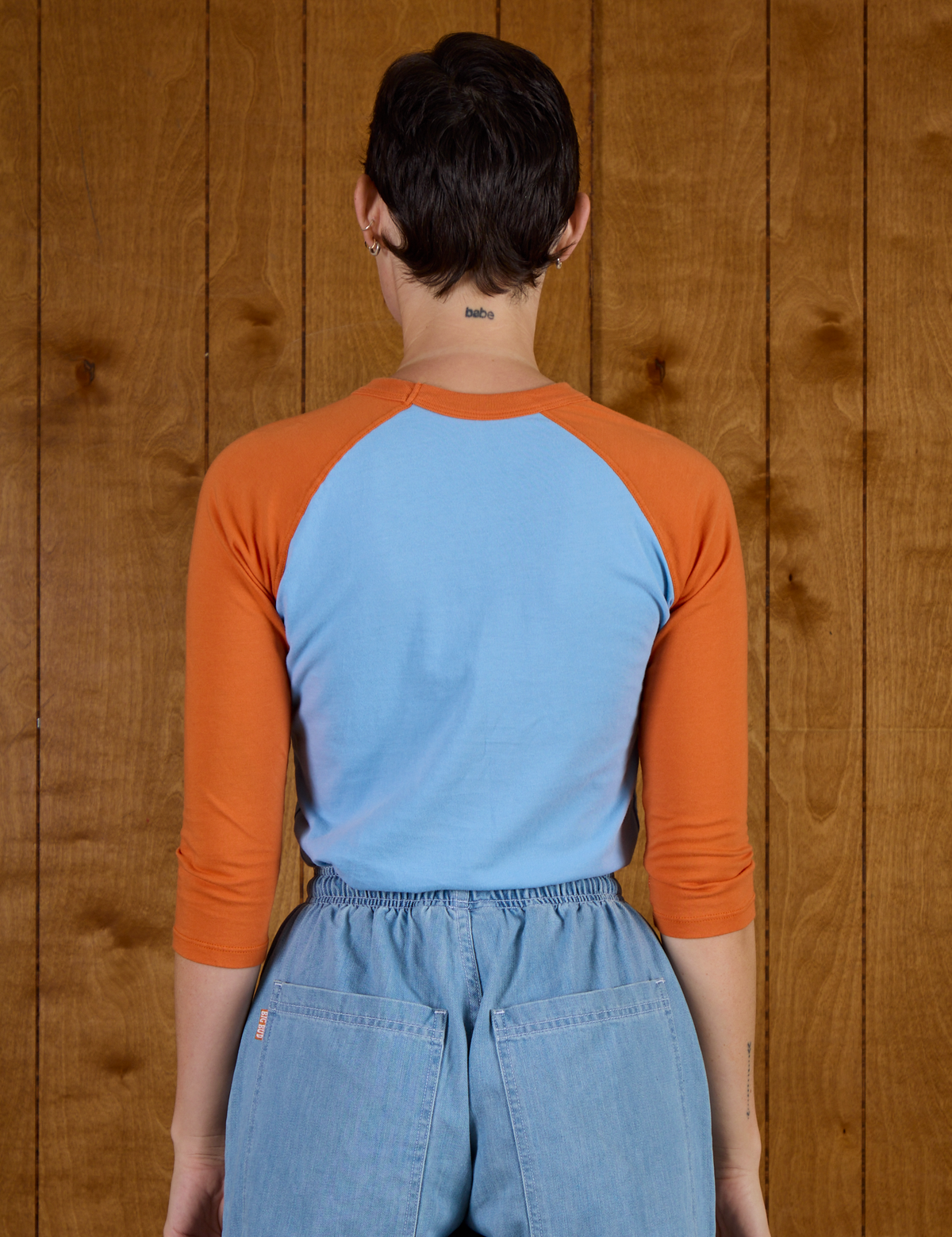 Back view of the Baby Blue/Orange Colorblock Raglan Tee on Alex