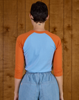 Back view of the Baby Blue/Orange Colorblock Raglan Tee on Alex