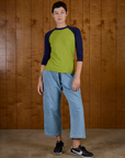 Alex is wearing the Gross Green/Navy Colorblock Raglan Tee with the Light Wash Denim Drop Pocket Pants