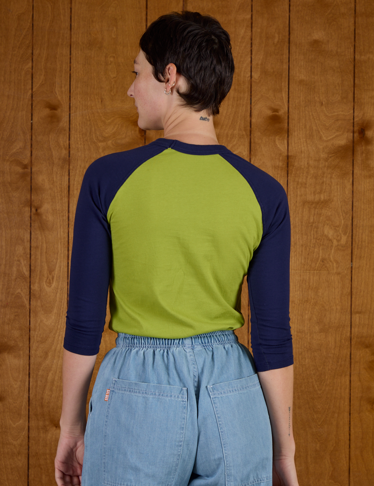 Back view of Alex wearing the Gross Green/Navy Colorblock Raglan Tee