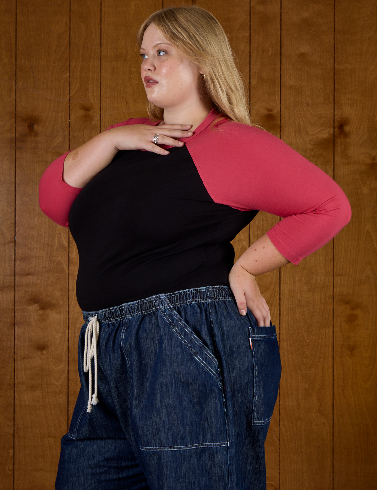 Angled side view of Juliet wearing the Black/Pink Colorblock Raglan Tee