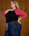 Angled side view of Juliet wearing the Black/Pink Colorblock Raglan Tee