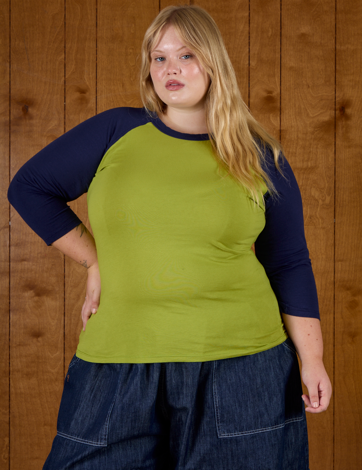 Juliet wearing  the Gross Green/Navy Colorblock Raglan Tee untucked