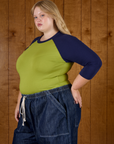 Angled side view of Juliet wearing the Gross Green/Navy Colorblock Raglan Tee