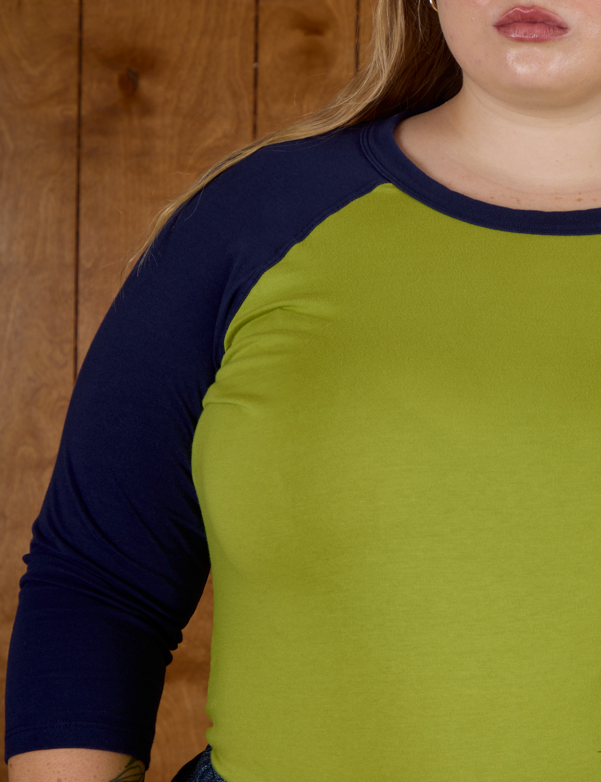Close up  he Gross Green/Navy Colorblock Raglan Tee's sleeve worn by Juliet