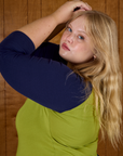 Close up side view of Juliet wearing the Gross Green/Navy Colorblock Raglan Tee