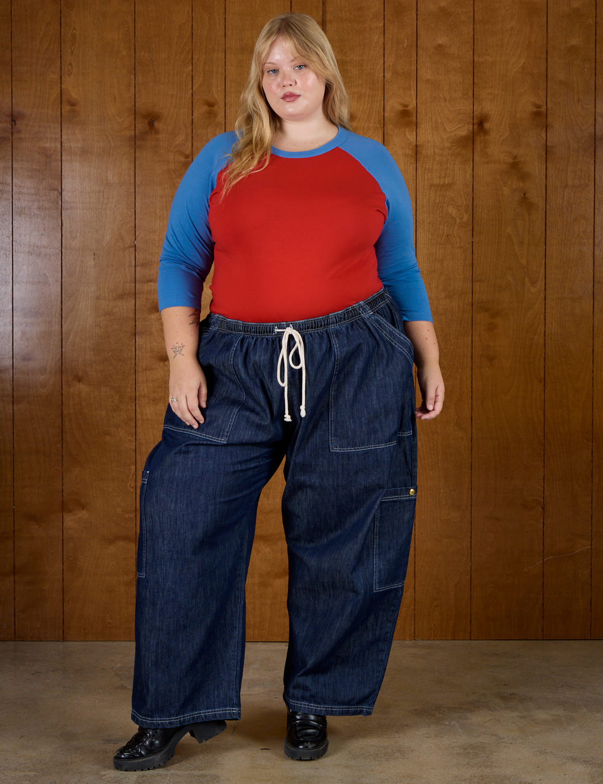 Juliet is 5'7" and wearing L Mustang Red/Blue Colorblock Raglan Tee with Dark Wash Drop Pocket Pants