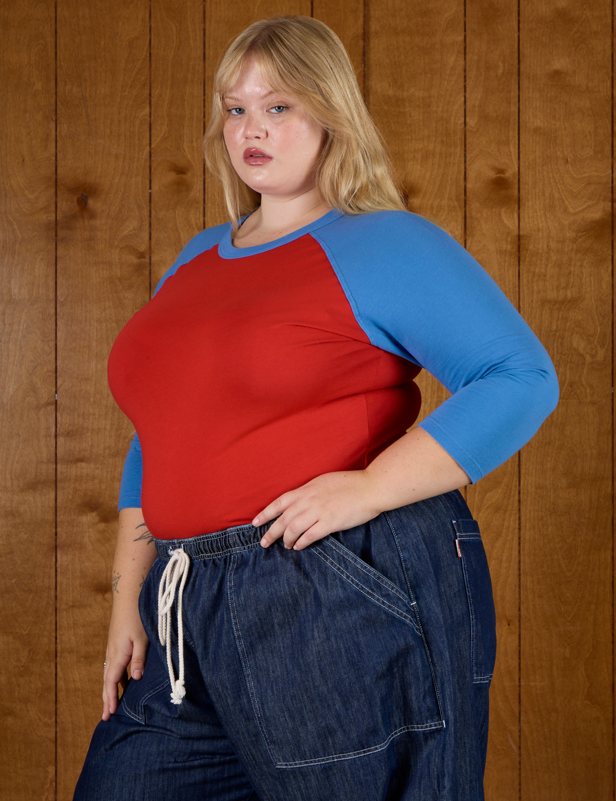 Angled side view of the Mustang Red/Blue Colorblock Raglan Tee on Juliet