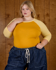 Juliet wearing the Mustard Yellow/Butter Raglan Tee tucked into Dark Wash Drop Pocket Pants