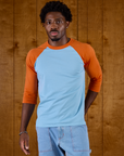 Isaac is 5'9" and wearing M Baby Blue/Orange Colorblock Raglan Tee