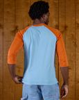 Back view of Isaac wearing the Baby Blue/Orange Colorblock Raglan Tee