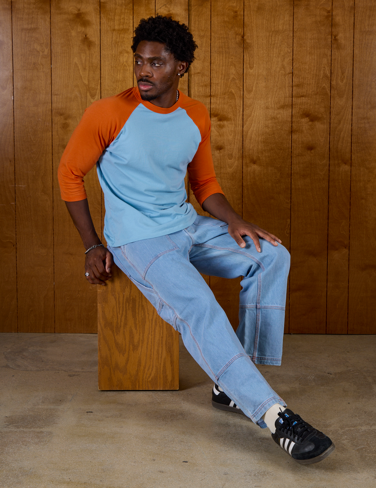 Isaac wearing the Baby Blue/Orange Colorblock Raglan Tee with Light Wash Carpenter Jeans