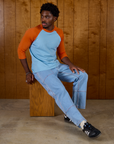 Isaac wearing the Baby Blue/Orange Colorblock Raglan Tee with Light Wash Carpenter Jeans