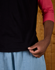 Close up of the hem on the Black/Pink Colorblock Raglan Tee worn by Isaac
