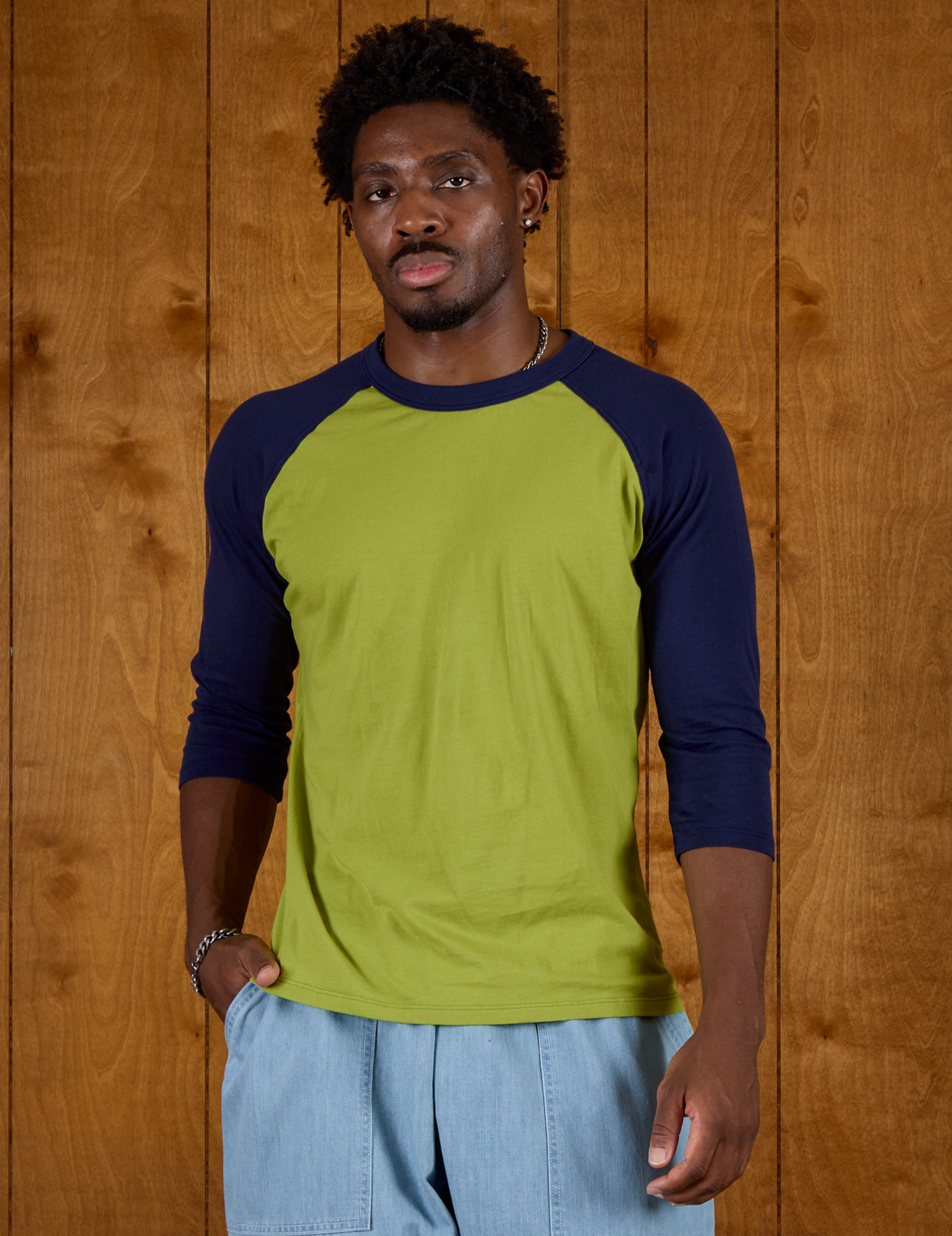 Isaac wearing  the Gross Green/Navy Colorblock Raglan Tee