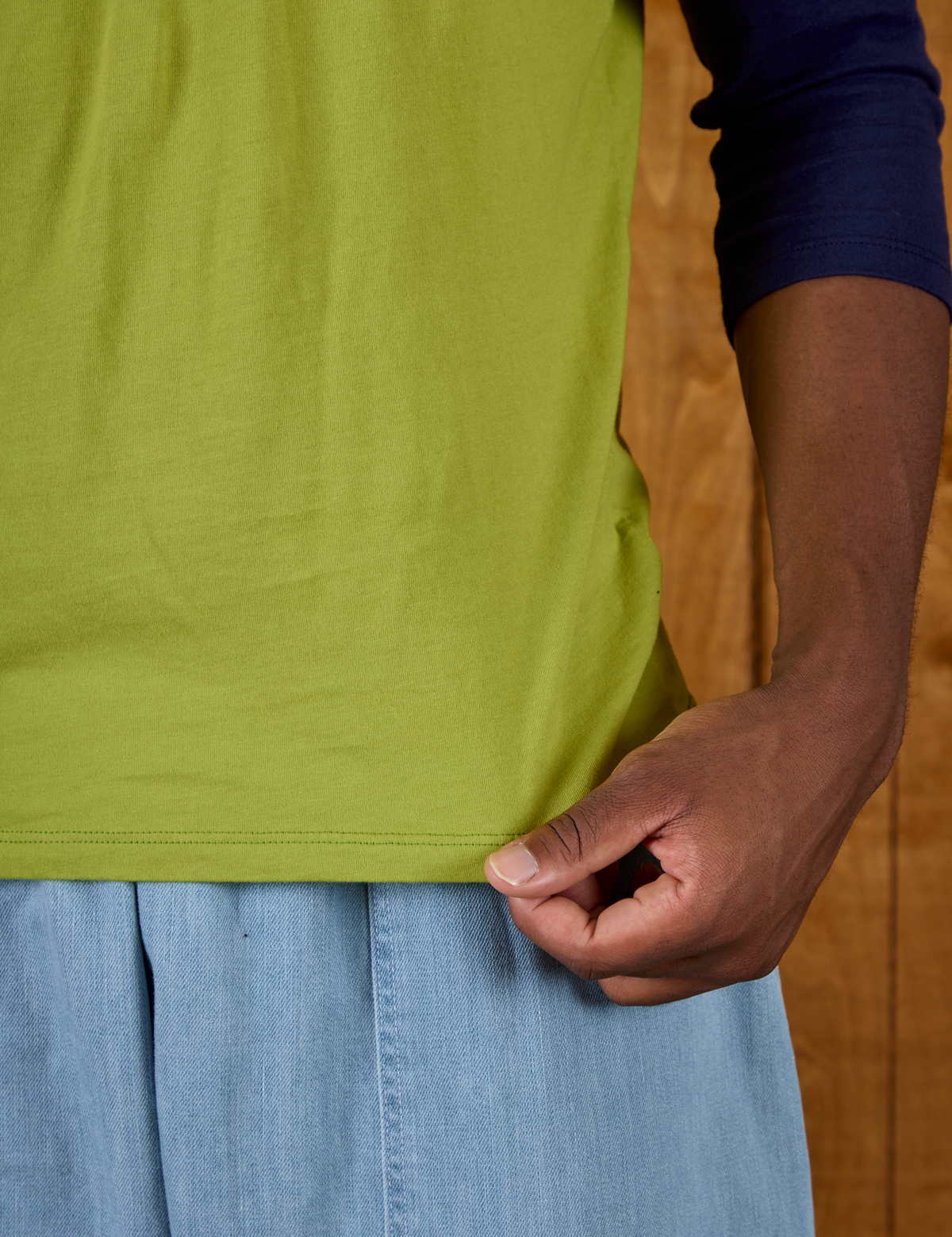Close up of the hem of  the Gross Green/Navy Colorblock Raglan Tee on Isaac
