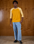 Isaac wearing the Mustard Yellow/Butter Raglan Tee with Light Wash Carpenter Jeans