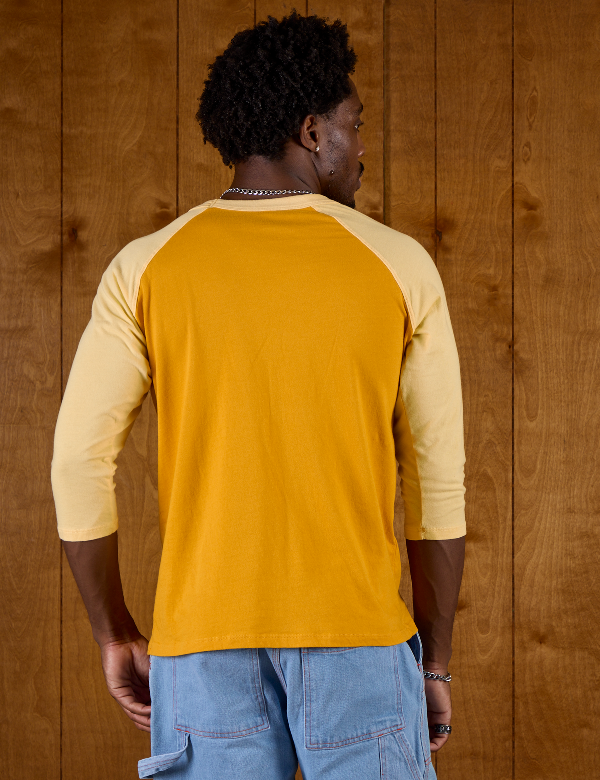 Back view of the Mustard Yellow/Butter Raglan Tee on Isaac