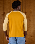 Back view of the Mustard Yellow/Butter Raglan Tee on Isaac