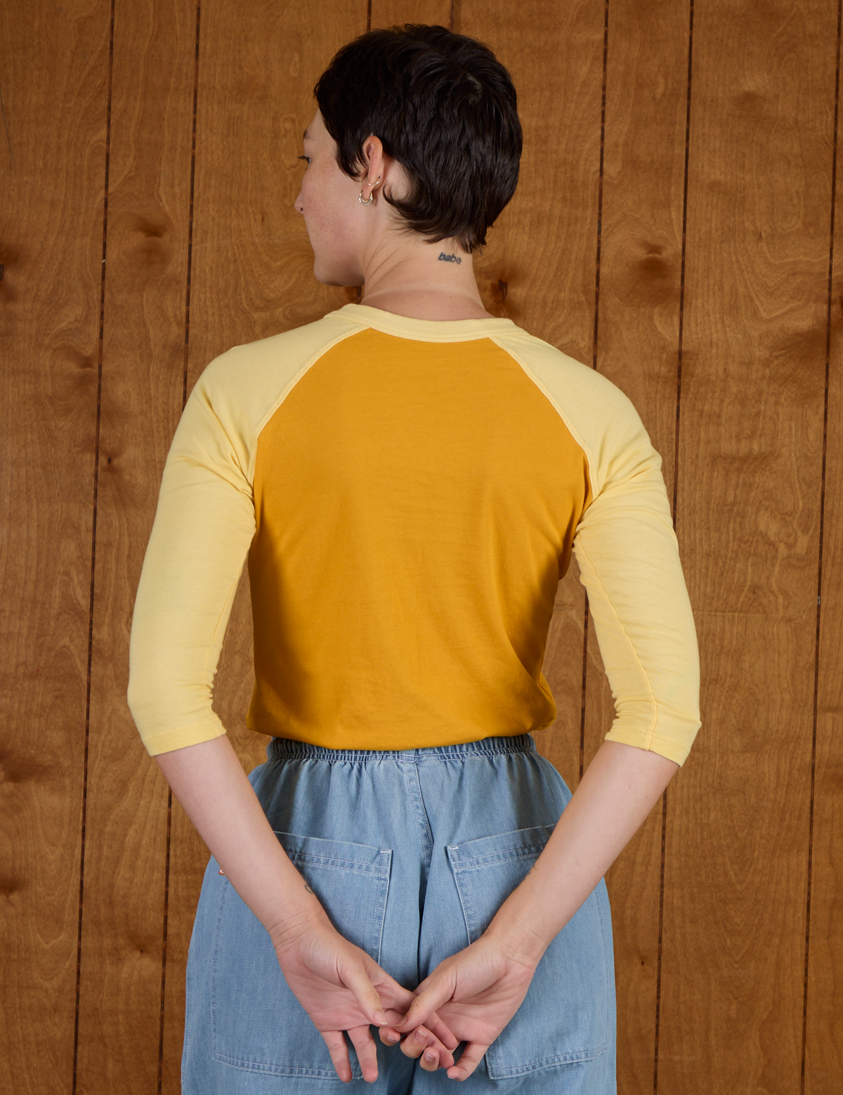 Back view of the Mustard Yellow/Butter Raglan Tee on Alex