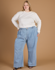 Juliet wearing the Vintage Tee White Long Sleeve Burly Tee tucked into the Light Wash Wide Leg Denim Trousers