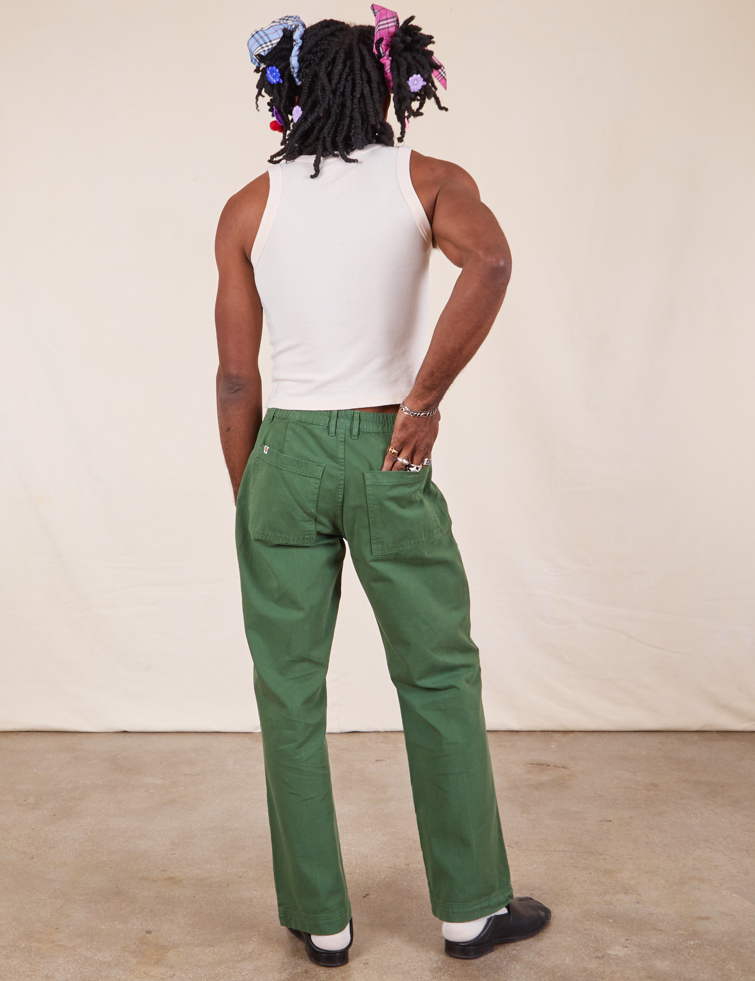 Back view of Western Pants in Dark Emerald Green and vintage off-white Cropped Tank Top on Jerrod
