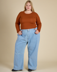 Juliet is wearing the Burnt Terracotta Long Sleeve Baby Tee with Light Wash Wide Leg denim Trousers