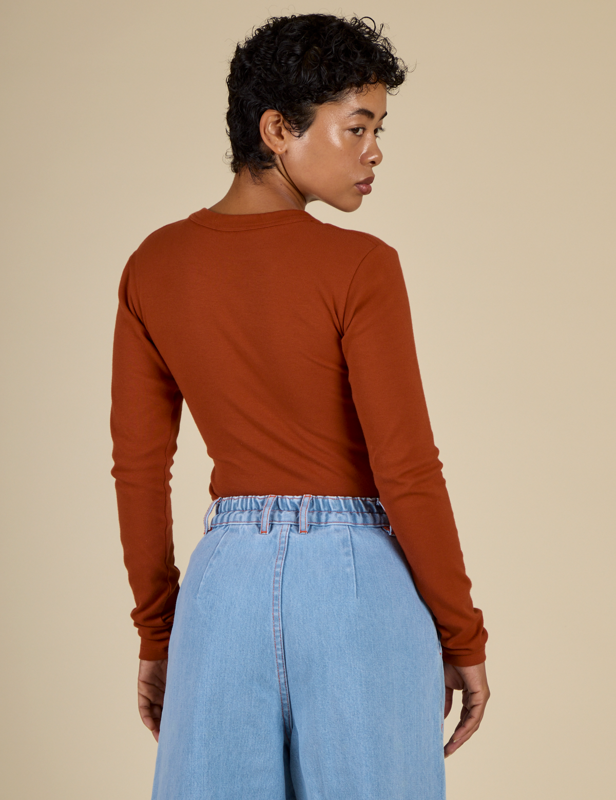 Back view of Mika in the Burnt Terracotta Long Sleeve Baby Tee