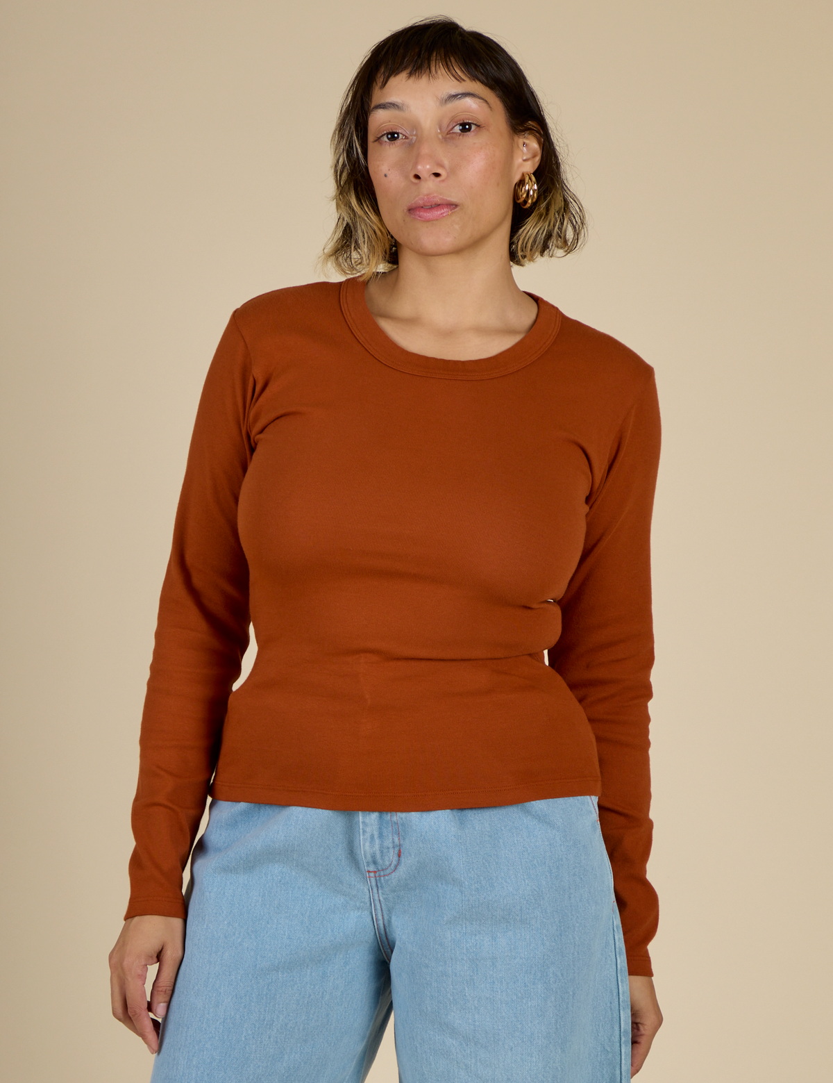 Tiara is 5'4" and wearing the Burnt Terracotta Long Sleeve Baby Tee