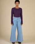 Mika is wearing the Nebula Long Sleeve Baby Tee tucked into the Petite Light Wash Wide Leg Trousers