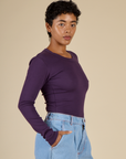 Side angled view of Mika in the Nebula Long Sleeve Baby Tee