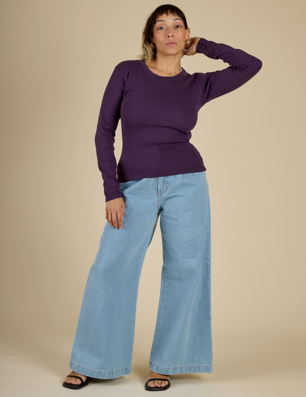 Tiara wearing the Nebula Long Sleeve Baby Tee with Light Wash Wide Leg Denim Trousers