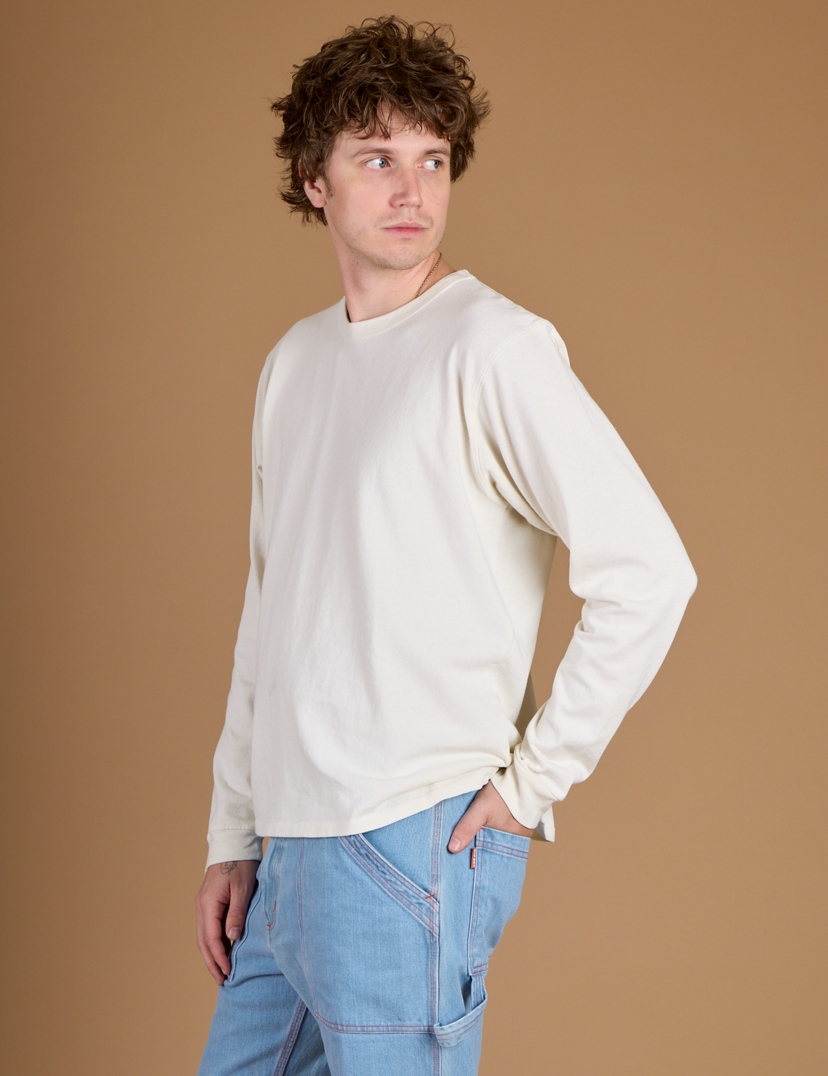Angled side view of Quinn wearing the Vintage Tee White Long Sleeve Burly Tee