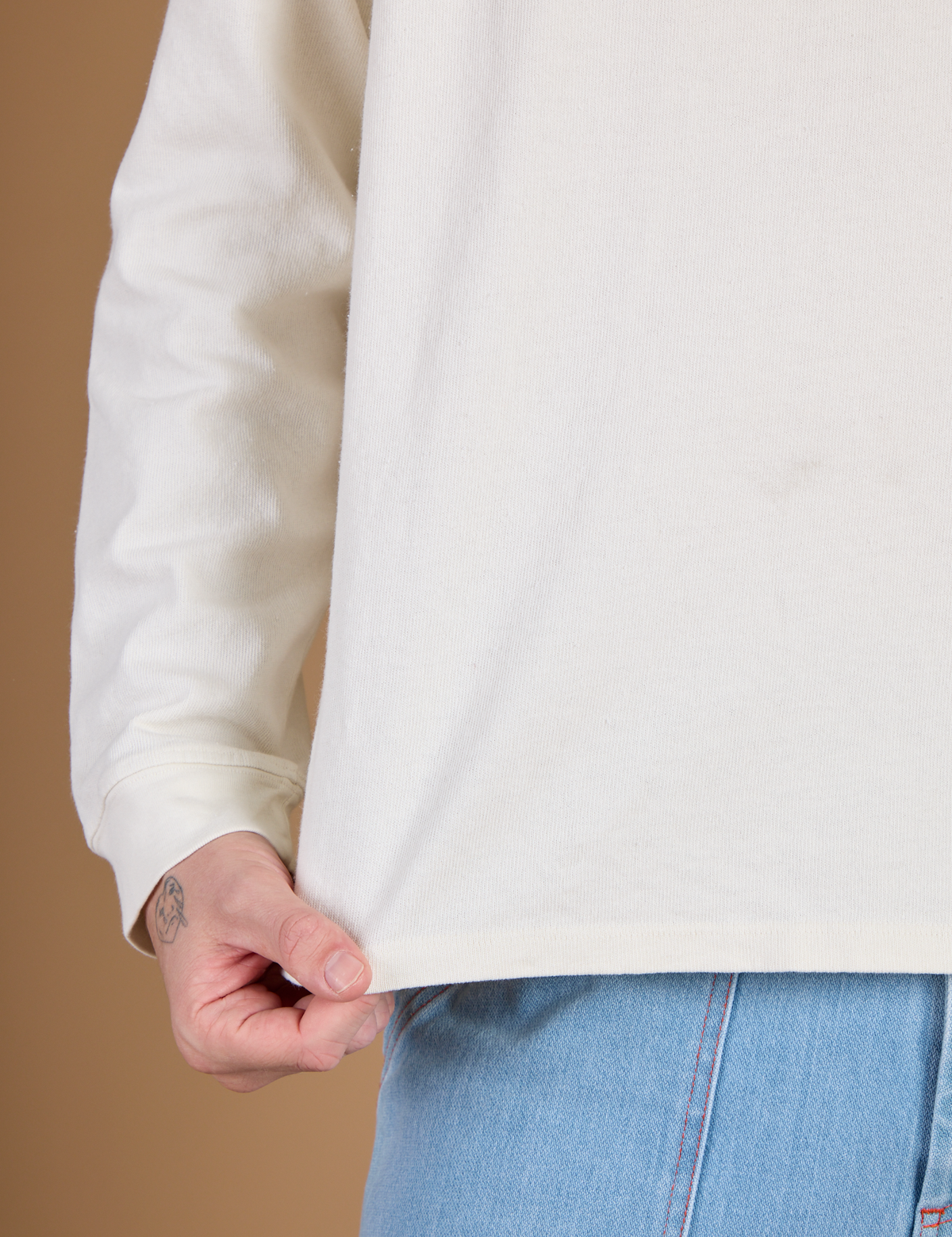 Close up of the hem on the Vintage Tee White Long Sleeve Burly Tee worn by Quinn