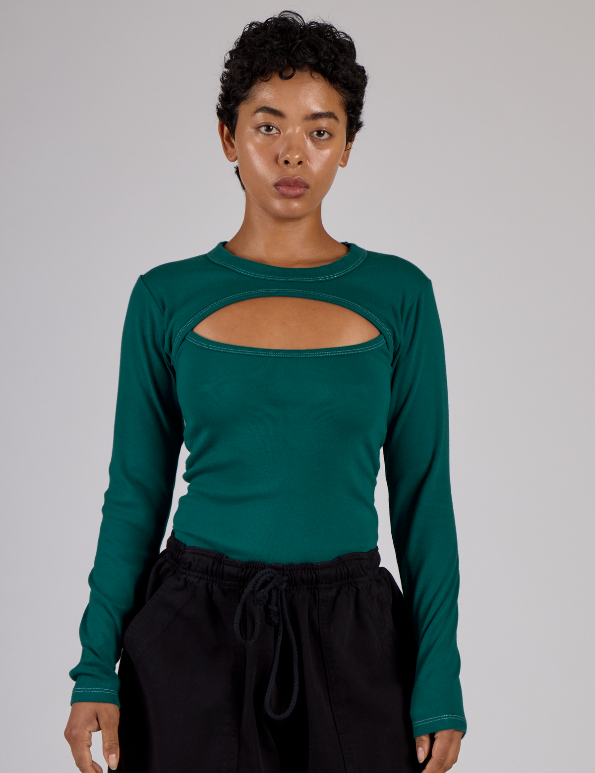 Mika wearing the Hunter Green Long Sleeve Porthole Tee tucked in