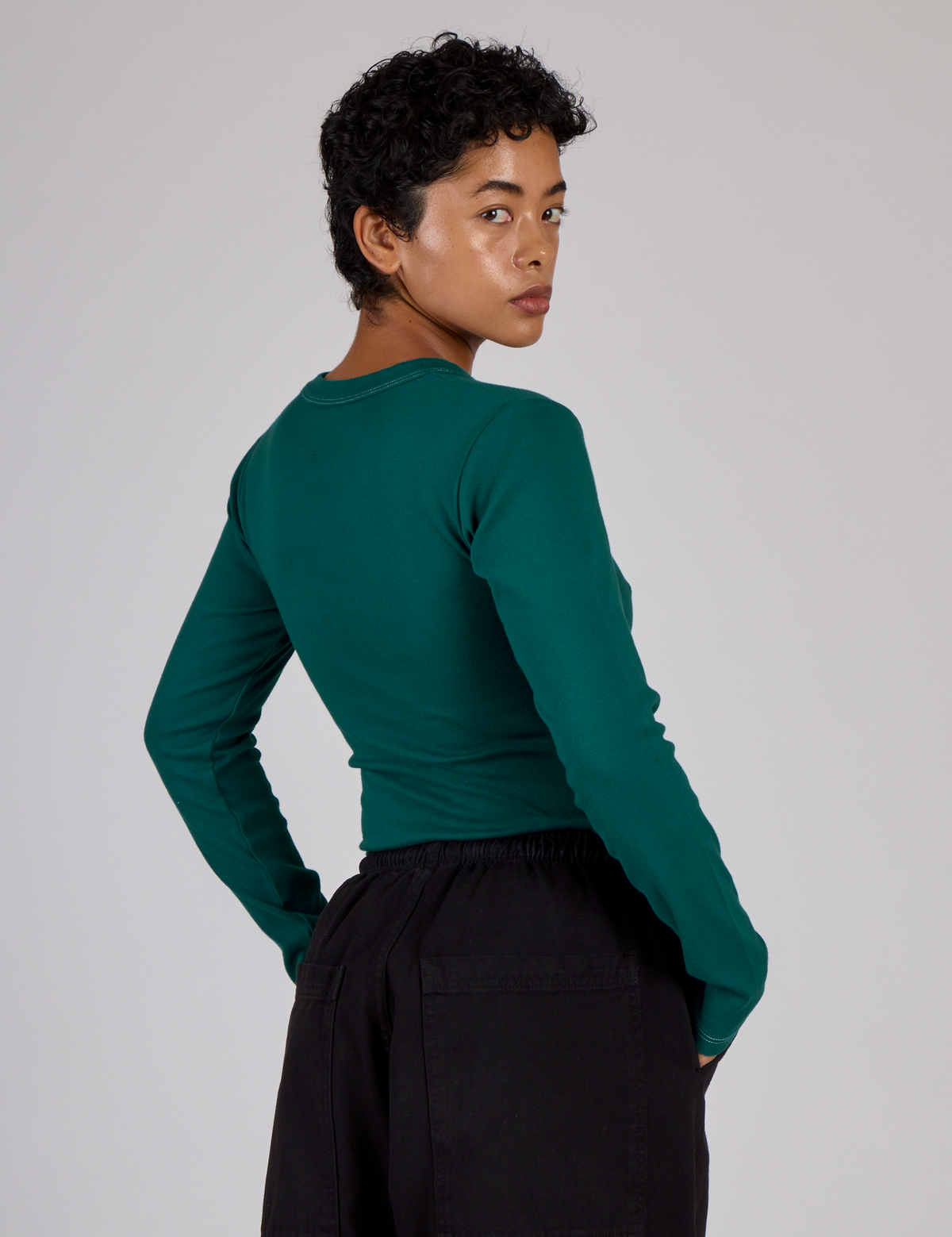 Angled back view of the Hunter Green Long Sleeve Porthole Tee on Mika